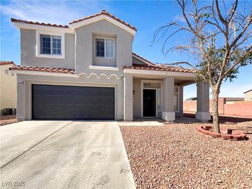 Two-story home featuring a two-car garage, low maintenance landscaping, and a covered front porch at 6696 Merced Lake Dr, Las Vegas, NV 89156