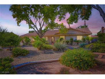 Charming home featuring desert landscaping, trees, and a tiled roof providing a welcoming exterior at 7385 Severence Ln, Las Vegas, NV 89131