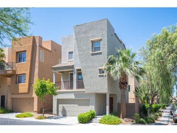 Contemporary two-story home featuring stucco siding, a balcony, and a well-manicured front yard at 9314 Hopcroft Ave, Las Vegas, NV 89178