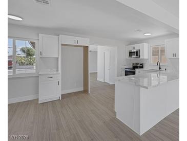 Modern kitchen featuring white cabinets, stainless steel appliances and light, wood-look flooring at 2005 Jansen Ave, Las Vegas, NV 89101