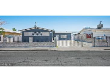 Modest single-story home with a gated front yard providing security and curb appeal at 2721 Merritt Ave, Las Vegas, NV 89102