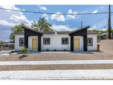 Charming duplex featuring a symmetrical design with clean white facade and yellow doors at 383 N 16Th St, Las Vegas, NV 89101