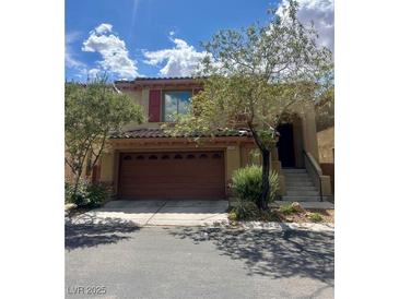 Charming two-story home with a two car garage, steps to entry, and lush landscaping at 9485 Whitewater Crest Ct, Las Vegas, NV 89178