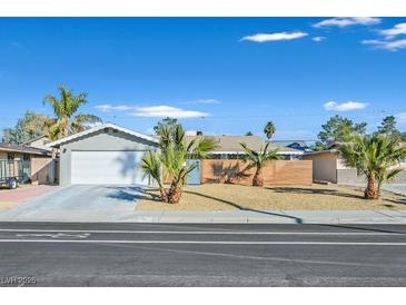 Charming single-story home featuring a well-maintained lawn with mature palm trees and an attached two-car garage at 105 Shadow Ln, Las Vegas, NV 89106