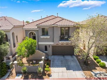 Two-story home featuring a tile roof, gray stucco exterior, and a two car garage at 11901 Luna Del Mar Ln, Las Vegas, NV 89138