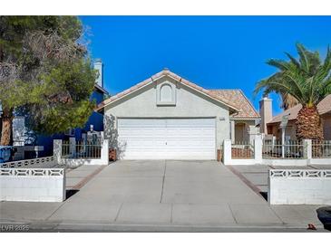 Charming single-story home with a two-car garage and a well-maintained front yard with mature trees at 1950 Turtlerock St, Las Vegas, NV 89142