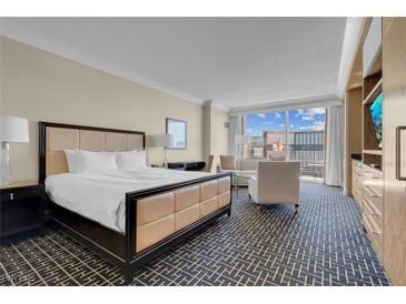 Cozy bedroom featuring a king-size bed, sitting area, and large windows with a cityscape view at 2000 Fashion Show Dr # 2400, Las Vegas, NV 89109