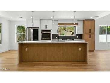 Modern kitchen featuring an island, stainless appliances, and abundant natural light at 2105 Madagascar Ln, Las Vegas, NV 89117