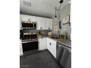 Well-lit kitchen with granite countertops, stainless steel appliances and white cabinetry at 2456 Desert Butte Dr, Las Vegas, NV 89134