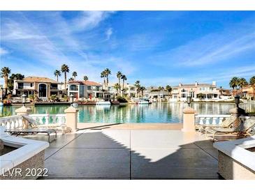 Beautiful back patio with water view, lounge chairs and patio furniture at 3111 Lido Isle Ct, Las Vegas, NV 89117
