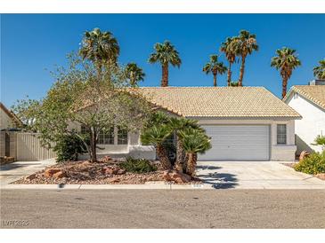 Charming single-story home with desert landscaping, tile roof, and a two-car garage surrounded by mature palm trees at 3414 Drescina Way, North Las Vegas, NV 89031