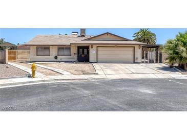 Single-story home featuring desert landscaping, a two-car garage, and neutral exterior color scheme at 4458 El Quinta Ct, Las Vegas, NV 89121