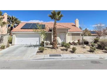 Charming single-story home featuring desert landscaping, solar panels, and a two-car garage at 5870 Grey Wood Way, North Las Vegas, NV 89031