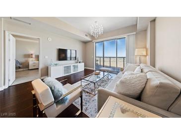 Bright living room featuring hardwood floors, modern furnishings, and sliding glass doors with mountain views at 8255 Las Vegas Blvd # 809, Las Vegas, NV 89123