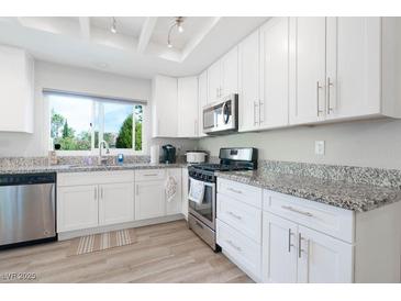 Bright kitchen featuring white cabinets, stainless steel appliances, and granite countertops at 8812 Marble Dr, Las Vegas, NV 89134
