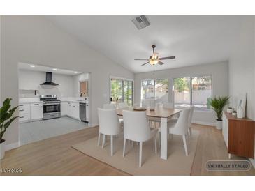 Bright dining room featuring modern white table and chairs, seamlessly flowing into the kitchen with white cabinets at 9513 Yucca Blossom Dr, Las Vegas, NV 89134