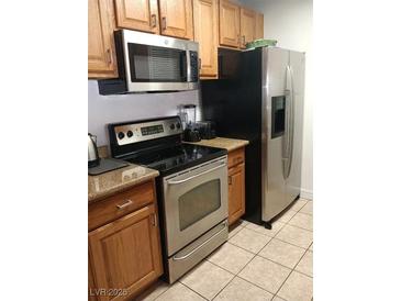 Kitchen features stainless steel appliances including microwave, oven, and refrigerator at 1515 E Reno Ave # D202, Las Vegas, NV 89119