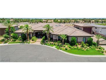 Beautiful single-story home with a tile roof, lush landscaping, and circular driveway at 8574 Verde Park Cir, Las Vegas, NV 89129