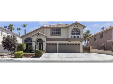 Charming two-story home featuring a neutral color palette, arched windows, and a well-maintained front yard at 1877 Glory Lily Ct, Las Vegas, NV 89123