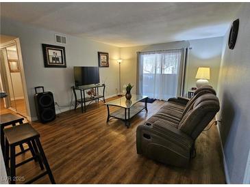 Cozy living room featuring hardwood floors, a plush sofa, and abundant natural light at 2451 N Rainbow Blvd # 1123, Las Vegas, NV 89108