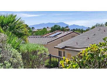 Beautiful house with a tile roof and solar panels in a lush green neighborhood with mountain views at 2548 Leighton Ave, Henderson, NV 89052