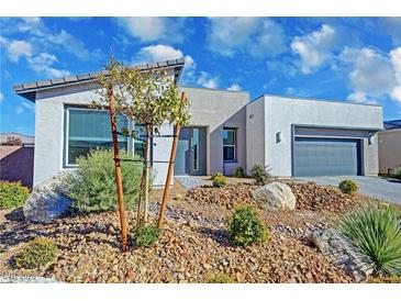 Contemporary home featuring desert landscaping, a two-car garage, and modern architectural design at 4717 S Maddington Ct, Pahrump, NV 89061