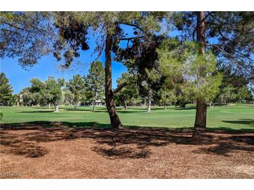 Scenic golf course view with mature trees and lush green fairways on a sunny day at 2851 Queens Courtyard Dr, Las Vegas, NV 89109
