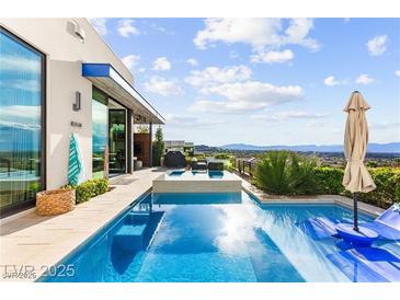 Inviting pool and spa with lounge area, complete with mountain views and desert landscaping, perfect for outdoor relaxation at 387 Solitude Peak Ln, Henderson, NV 89012