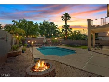 Inviting backyard with a sparkling pool, fire pit, string lights and comfortable patio space, perfect for outdoor entertaining at 741 Wildwood Beach Ave, Henderson, NV 89052