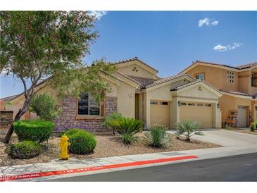 Charming single-story home featuring stone accents, a two-car garage, and a well-maintained desert landscape at 83 Buckthorn Ridge Ct, Las Vegas, NV 89183