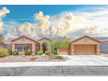 Inviting single-story home with a three-car garage and desert landscaping under a blue sky at 1641 Rockcrest Hills Ave, Henderson, NV 89052