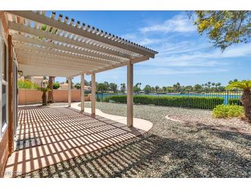 Inviting covered back patio boasts tranquil lake views and ample space for outdoor entertaining at 2537 Seascape Dr, Las Vegas, NV 89128