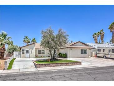 Charming single-story home with landscaped yard and palm trees against a blue sky at 905 Smith St, Las Vegas, NV 89108