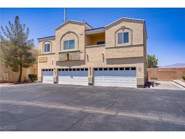 Three-story home featuring three garage doors and a tan stucco exterior, under a bright blue sky at 4020 Smokey Fog Ave # 3, North Las Vegas, NV 89081