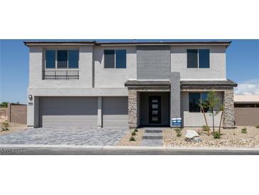 Stunning two-story home with modern design, two-car garage, and stone accents creating a welcoming curb appeal at 7199 Twilight Rider Ct, Las Vegas, NV 89118