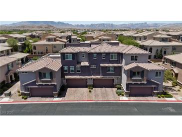 Modern townhome showcases a unique purple exterior, complemented by a tile roof and multiple garage spaces at 10013 Sable Point St, Las Vegas, NV 89178