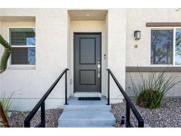 Inviting front entrance featuring a stylish black door, concrete steps, and sleek black railings at 12237 Plum Mist Ct # 4, Las Vegas, NV 89183