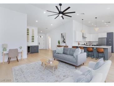 Bright open-concept living room with modern furnishings and a view of the kitchen at 2475 Sedona Cedar Ave, Henderson, NV 89052