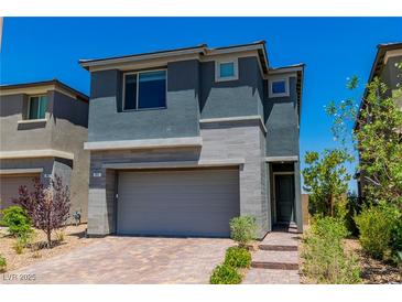 Two-story home with gray stucco, brick accents, and a two-car garage at 312 Wind Poppy St, Las Vegas, NV 89138