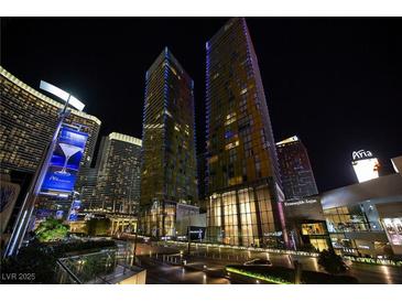 Stunning night view of the modern high-rise with illuminated signage and beautiful landscaping at 3722 Las Vegas Blvd # 2512 E, Las Vegas, NV 89158