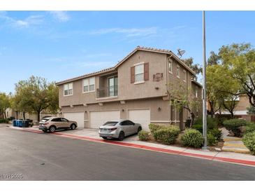 Three-story townhome with a tan exterior, red tile roof and three garages in a well maintained community at 390 Clarence House Ave # 1, North Las Vegas, NV 89032