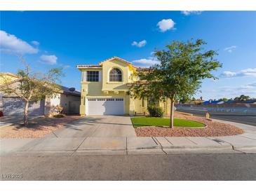Charming two-story home featuring a two-car garage, manicured lawn, and beautiful landscaping at 5907 Soft Mist Ct, Las Vegas, NV 89110