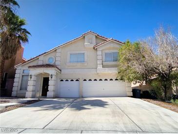 Two-story home with a stucco facade, arched entry, and an attached two-car garage at 6608 Buried Treasure Ct, Las Vegas, NV 89139