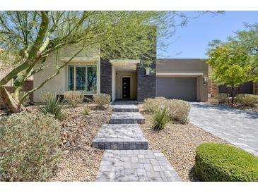 Charming single-story home with desert landscaping and a stone walkway leading to the front door at 10349 Bressana Dr, Las Vegas, NV 89135