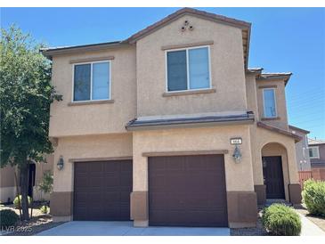 Two-story home featuring a two car garage, landscaped yard, and classic desert architecture at 664 Forest Peak St, Henderson, NV 89011