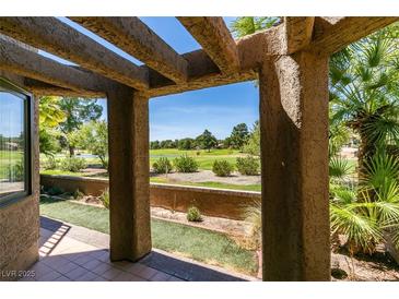 View of golf course from covered back patio with desert landscaping and beautiful pergola at 7132 Mission Hills Dr, Las Vegas, NV 89113