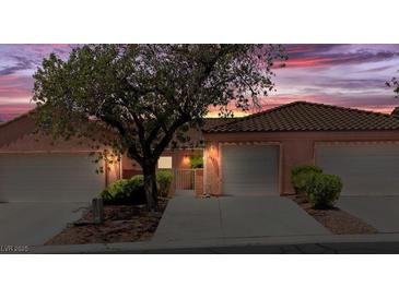 Charming single-Gathering home with attached garage, tile roof, desert landscaping, and a view of the vibrant sunset sky at 731 Appletree Ln, Mesquite, NV 89027
