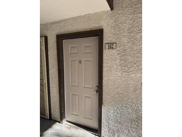 Beige front door with unit number 142 featured on the exterior of the building at 2606 S Durango Dr # 142, Las Vegas, NV 89117