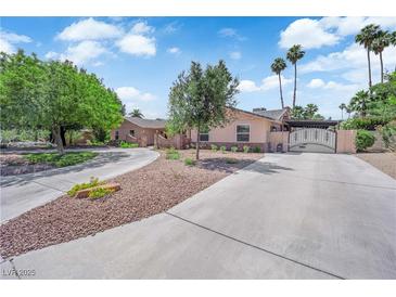 Charming single-story home with a circular driveway, mature trees, and secure gated entrance at 3753 Meadowcrest Dr, Las Vegas, NV 89121