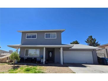 Two-story home featuring a gray exterior, covered porch, and a two-car garage on a sunny day at 4291 Powell Ave, Las Vegas, NV 89121